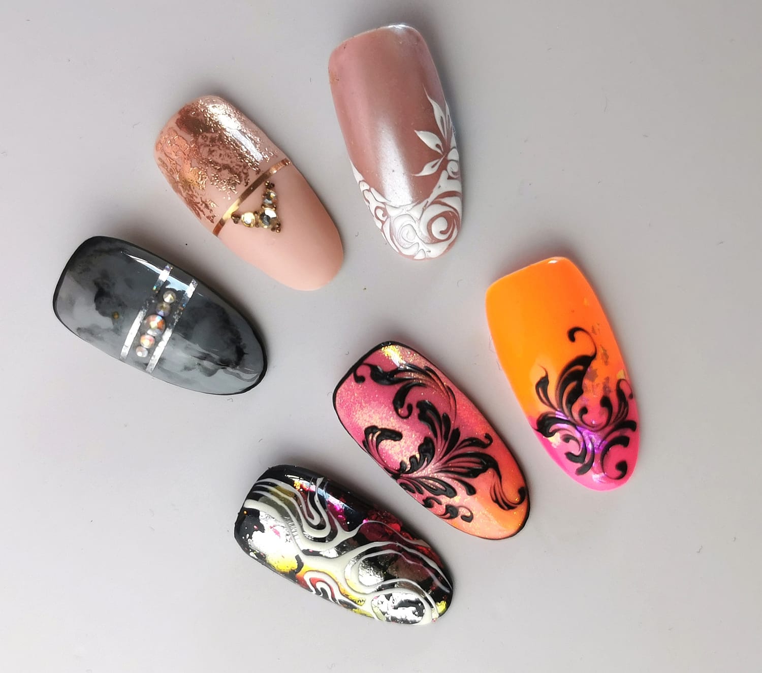Six hand-painted nail art designs on a light background